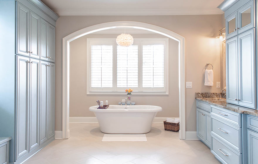 Calming blue painted cabinetry creates a peaceful retreat while floor to ceiling cabinetry provides storage to hide everything away.