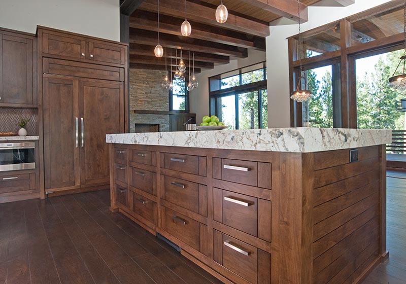 The beauty of stained Alder fits perfectly in this kitchen, perched in the mountains' natural surroundings.