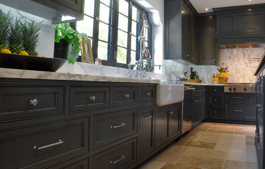 Dark paint creates a dramatic look in this kitchen with all the right custom details.