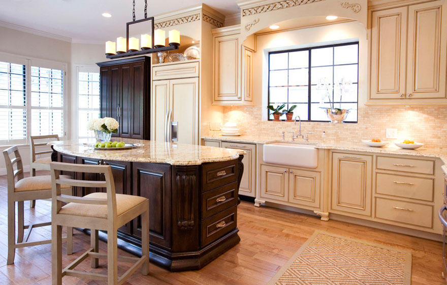 Dramatic and elegant, this two-tone kitchen design with light colored wall cabinetry keeps the space open and airy while the dark, luxurious island creates a rich focal point.