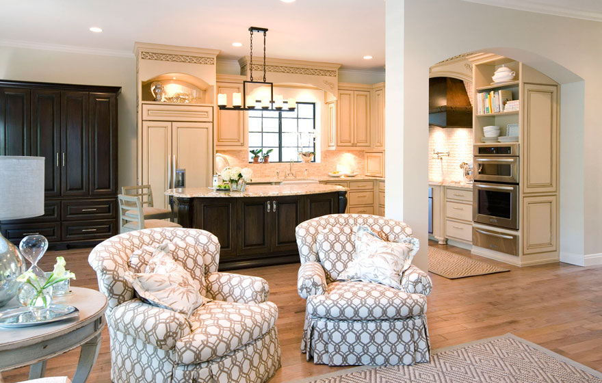 Dramatic and elegant, this two-tone kitchen design with light colored wall cabinetry keeps the space open and airy while the dark, luxurious island creates a rich focal point.