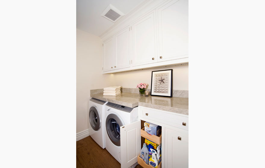 Custom designed wood cabinet doors in a compact laundry room off the kitchen for ease of use.  