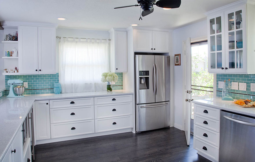 Clean and crisp cabinets pair well with the splash of color in the backsplash.